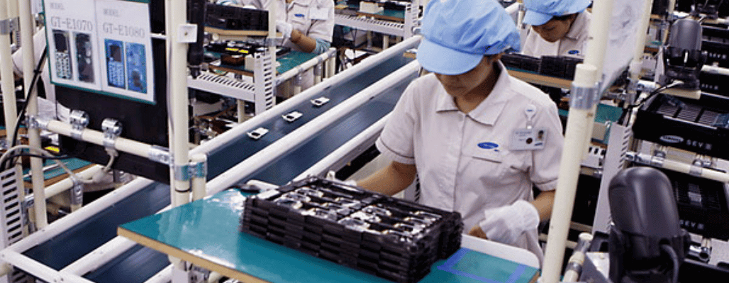 Workers assembling electronics in a factory.